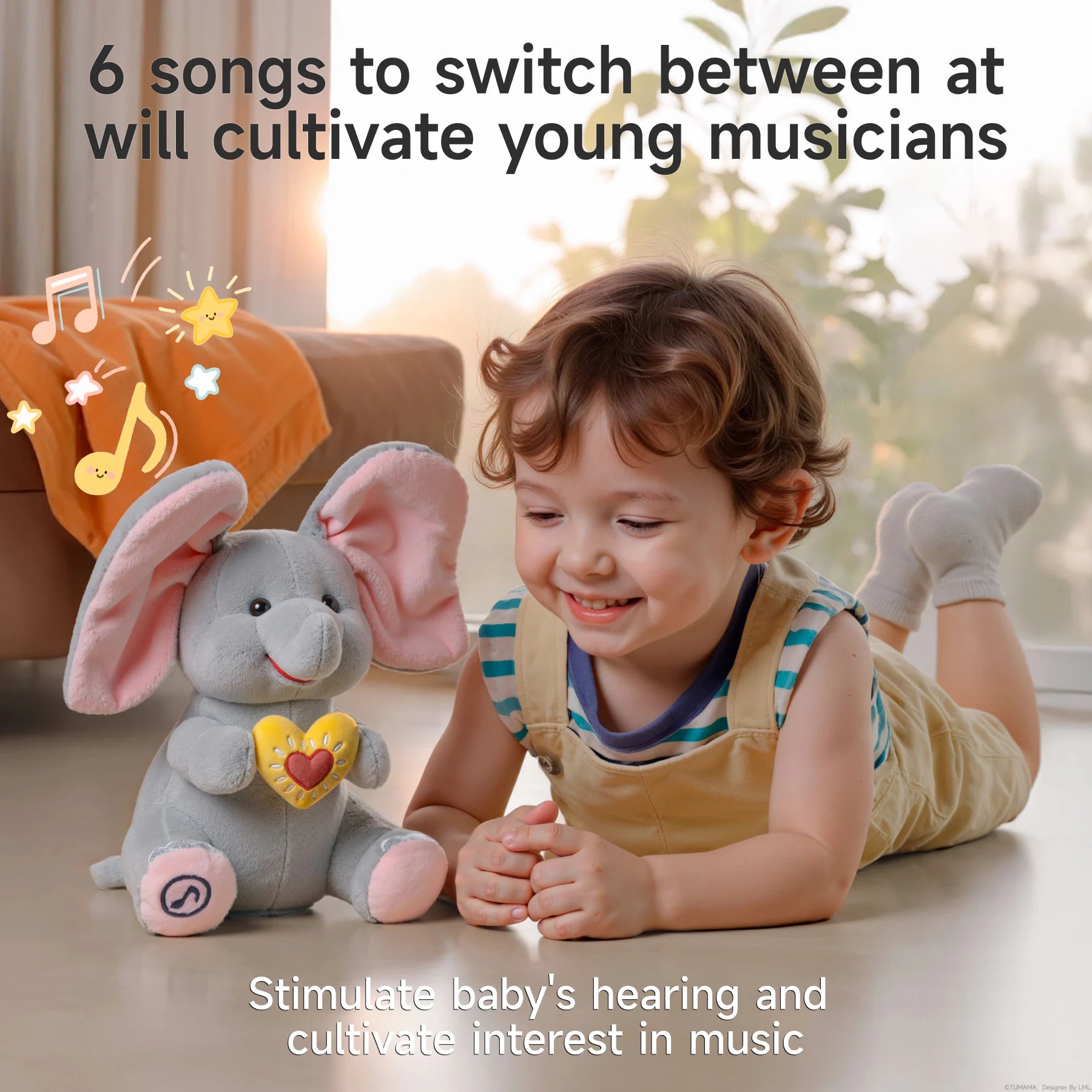 A smiling toddler lying on the floor next to an interactive elephant plush toy with large pink ears and a yellow heart on its chest. Musical notes and stars float above the toy, illustrating its music feature. Text reads: '6 songs to switch between at will cultivate young musicians' and 'Stimulate baby’s hearing and cultivate interest in music.'