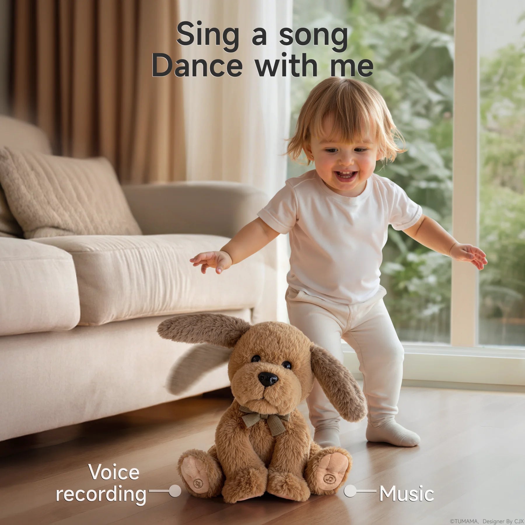 A smiling toddler in white clothes stands next to a brown interactive singing and dancing puppy stuffed toy on a wooden floor in a bright living room. The puppy toy has floppy ears and a bow tie. Text at the top reads