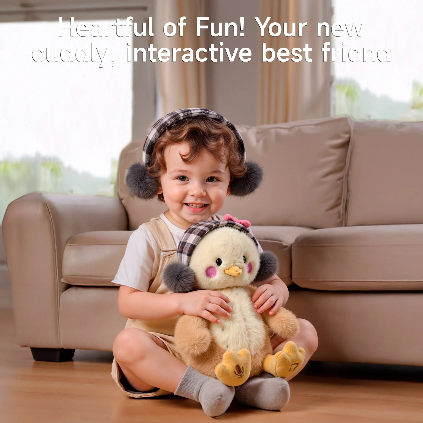 A smiling toddler sitting on the floor in a living room, wearing gray earmuffs and holding a cute interactive plush chick toy with pink cheeks and plaid earmuffs.