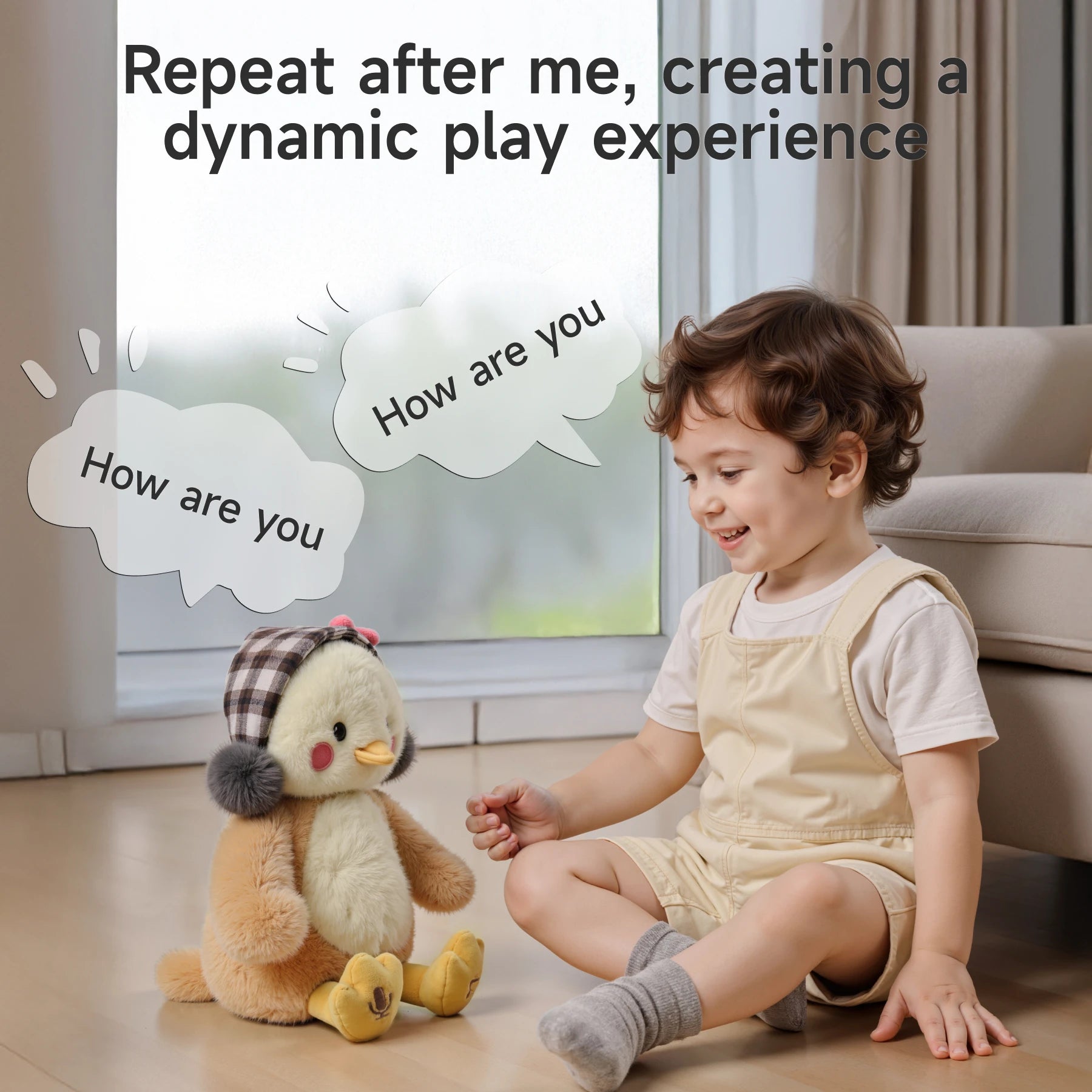 A smiling toddler sitting on the floor facing a cute interactive plush chick toy with plaid earmuffs and a pink bow. Speech bubbles saying ‘How are you’ indicate the toy’s repeat function.