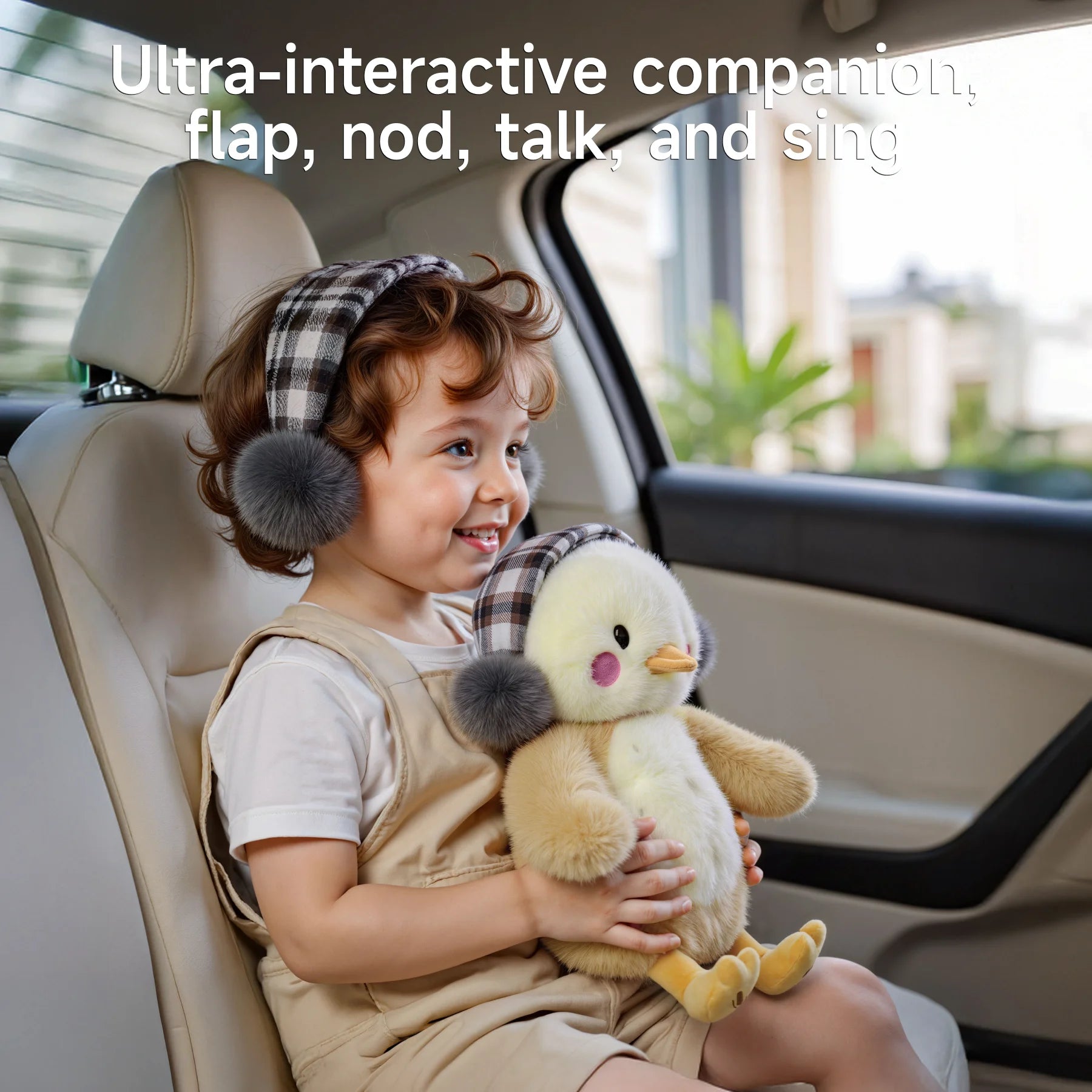 A smiling toddler sitting in a car seat, holding a cute interactive plush chick toy with plaid earmuffs and a pink bow. Text at the top reads ‘Ultra-interactive companion, flap, nod, talk, and sing.’
