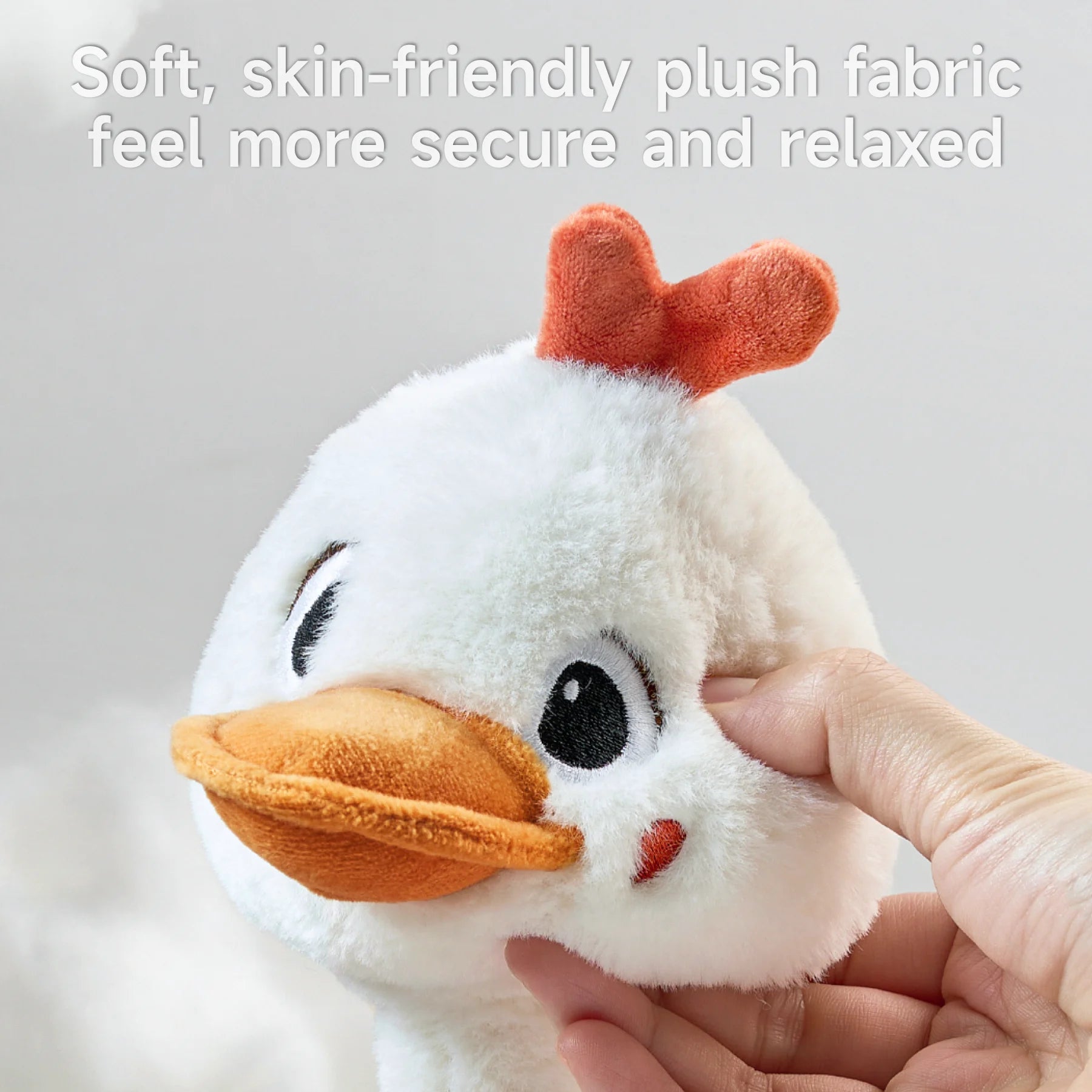 Close-up of a plush duck toy's soft, skin-friendly fabric being gently squeezed by a hand, showcasing its smooth and relaxing texture. Designed for safe and comfortable play for children.
