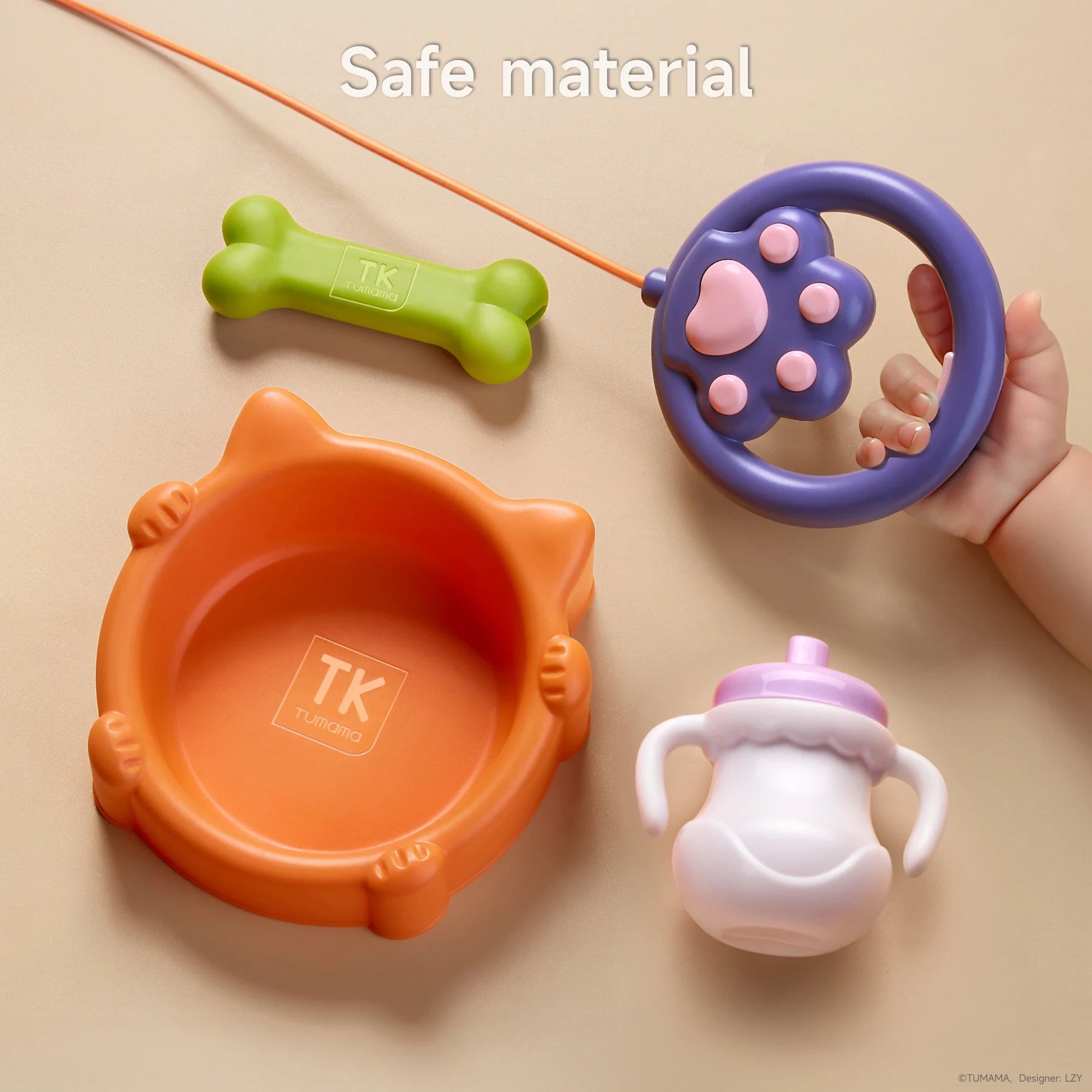 Close-up of toy dog accessories, including a cat-shaped orange food bowl, green bone, baby bottle, and paw-shaped leash remote, all made with child-safe materials and smooth edges.