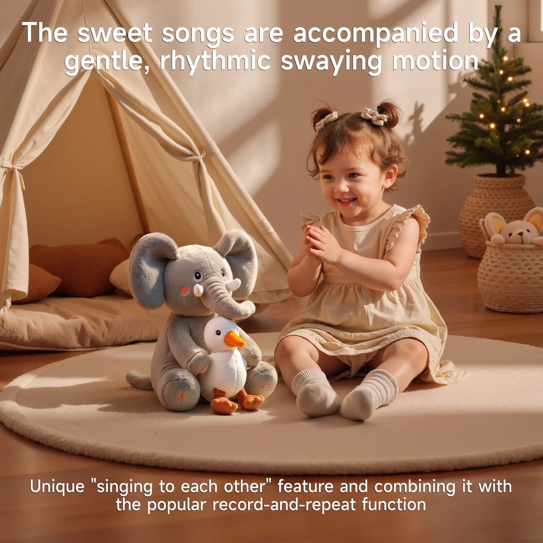 Happy toddler clapping while sitting beside an interactive elephant and bird plush toy that sings and sways, in a cozy indoor playroom with a teepee tent and Christmas tree.