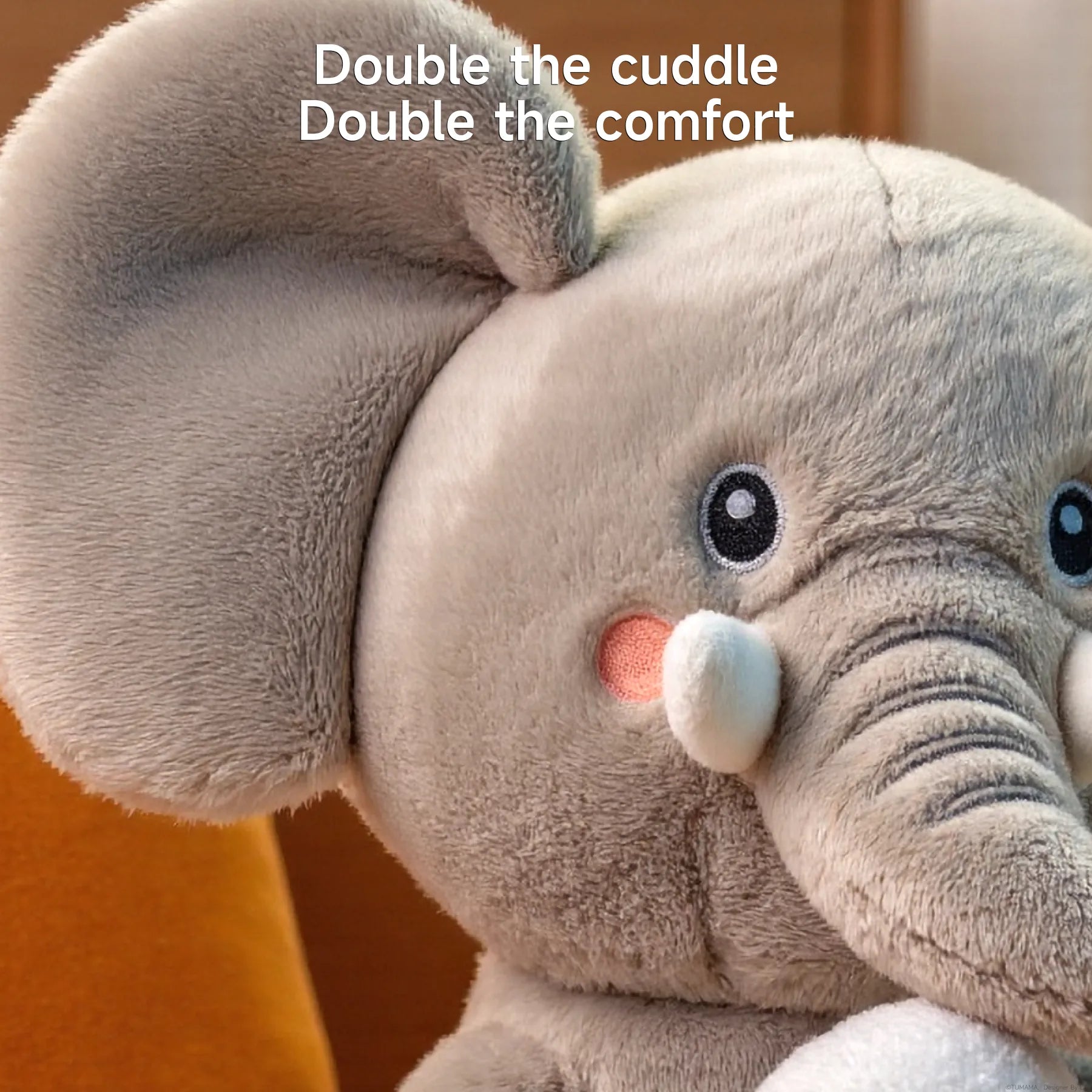 Close-up of soft plush elephant toy showing detailed stitching and velvety texture, with the text “Double the cuddle, Double the comfort” emphasizing its cozy design.