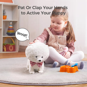 A young girl playing with a sound-activated plush puppy wearing a sparkly pink bowtie. The puppy responds to her patting with a 